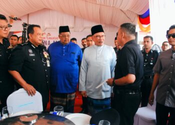 ANWAR Ibrahim berbual dengan seorang anggota polis yang menerima sumbangan sempena Majlis Ramah Mesra di IPD Melaka Tengah, Banda Hilir, Melaka. - UTUSAN/AMRAN MULUP