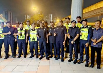 M. KUMAR (tengah) bergambar bersama pegawai dan anggota yang terlibat dalam Op Selamat di persimpangan Bangunan Sultan Iskandar-Jalan Lingkaran Dalam, Johor Bahru.