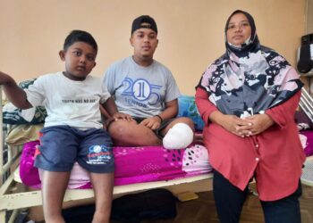 ROSMAH Ahmad menunjukkan kaki kiri Muhamad Haikal Syed Abdul Kadir yang masih berbalut ketika ditemui di rumah mereka di Kampung Ulu Paip, Karangan di Kulim semalam.