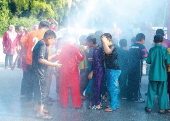 KANAK-KANAK gembira apabila dihujani pancutan air daripada bomba dan penyelamat dalam program berkhatan di Sekolah Agama (SA) Kampung Sawah, Pekan Nanas, Pontian, Johor, baru-baru ini. - UTUSAN/MUHAMMAD ZIKRI