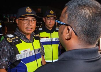 LOKMAN Jamaan ketika menegur perbuatan lelaki itu yang membawa bas persiaran tanpa lesen di Plaza Tol Kemuning, Shah Alam, malam tadi. - UTUSAN/ SADDAM YUSOFF