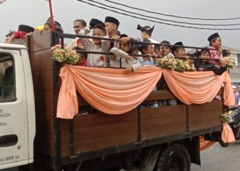 KANAK-kanak diarak menaiki lori berhias mengelilingi kampung sebelum berkhatan di Seri Manjung, Perak, hari ini. - UTUSAN