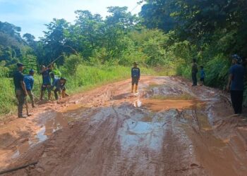 PENDUDUK Orang Asli di beberapa penempatan membaiki jalan yang berlumpur, berlubang dan rosak ketika hujan di Pos Sinderut, Ulu Jelai, Lipis, Pahang. - UTUSAN/HARIS FADILAH AHMAD