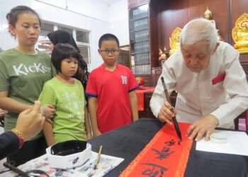 WONG Weng Chong menulis kaligrafi Cina untuk diberikan kepada penduduk di Kampung Baru, Gua Musang, Kelantan. - UTUSAN/AIMUNI TUAN LAH