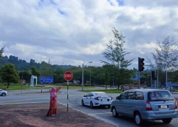 SHAZAA SHAFARUDDIN menunjukkan lampu isyarat yang tidak berfungsi dengan baik di simpang empat Jalan Temoh berhampiran Taman Awam Tasek Temoh, Tapah. - UTUSAN