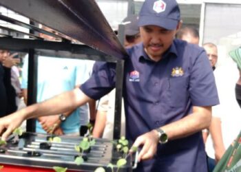 MOHD. Jafni Md. Shukor mengangkat sayur yang ditanam oleh komuniti pada Program Pemekasaan Komuniti di RSK Cendana dan Perasmian Waqaf Tani Komuniti di Taman Cendana, Pasir Gudang, Johor Bahru, hari ini. - UTUSAN/BAAZLAN IBRAHIM