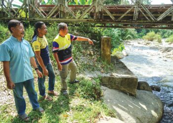 PENDUDUK menunjukkan tempat berlaku kejadian kepala air menyebabkan empat sekeluarga maut di Sungai Kenjur dekat Kampung Poh, Bidor, Perak. - UTUSAN/ZULFACHRI ZULKIFLI