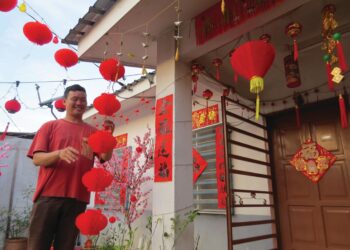 CHIN Qi Yao menghias rumahnya dengan bunga Meihua dan tanglung sempena sambutan Tahun Baharu Cina di Kampung Batu Papan 2, Gua Musang, Kelantan.– UTUSAN/AIMUNI TUAN LAH