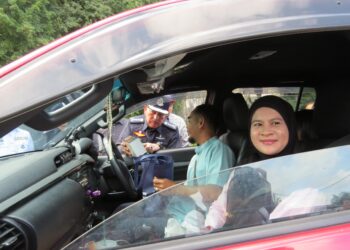 MUHAMAD Zaki Harun (kiri) menyantuni pengguna jalan raya pada Program Keberkesanan Op Selamat 21/2024 sempena Tahun Baharu Cina di perkarangan Muse Eco Park di Gua Musang, Kelantan, hari ini.-UTUSAN/AIMUNI TUAN LAH