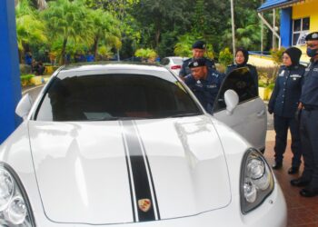 NADZRI Che Ani melihat sebuah kereta mewah Porsche Panamera dipercayai diseludup dari negara jiran melibatkan cukai berjumlah RM286,000 di Pejabat JKDM Melaka, Lebuh Ayer Keroh, Melaka. - UTUSAN/AMRAN MULUP