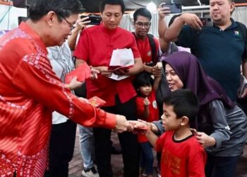 CHOW Kon Yeow (kiri) menyerahkan angpau kepada seorang kanak-kanak ketika menghadiri Majlis Rumah Terbuka Tahun Baharu Cina Parlimen Batu Kawan di Juru, Bukit Mertajam, Pulau Pinang