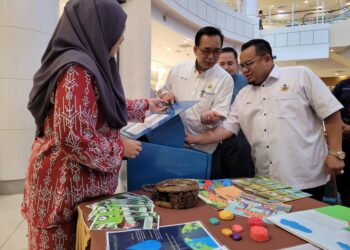 HILMI Abdullah (kanan) melihat keunikan sebuah tong sampah di salah satu gerai pameran pada Majlis Pelancaran Kota Bharu Bebas Beg Plastik di sebuah pasaraya di Kota Bharu, Kelantan hari ini. UTUSAN/MUSTAQIM MOHAMED