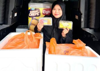 RABIATUL Adawiah Ibrahim menunjukkan produk durian crepe keluaran syarikatnya yang sedia untuk dihantar kepada ejen-ejen di seluruh negara. - UTUSAN / ABDUL RAZAK IDRIS