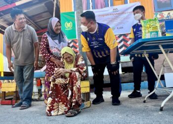 TUANKU Syed Faizuddin Putra Jamalullail (dua dari kanan) berkenan menyantuni Minah Md Aris, 86, (duduk) sewaktu Program Kayuhan UDA Cares Bersama Raja Muda Perlis di Kampung Nelayan Warna Warni Sebarang Ramai, Perlis hari ini. -UTUSAN/ASYRAF MUHAMMAD