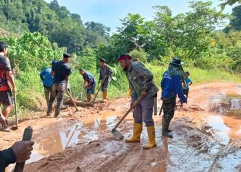 Penduduk Orang Asli di beberapa penempatan sedang membaiki jalan yang berlumpur, berlubang dan rosak ketika hujan di Pos Sinderut, Ulu Jelai, Lipis, Pahang - HARIS FADILAH AHMAD