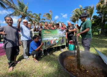 DERAMAN Abas (tiga dari kanan) bersama kumpulan petani menjayakan majlis kesyukuran di bendang Gong Manak, Pasir Puteh, Kelantan. - UTUSAN/TOREK SULONG