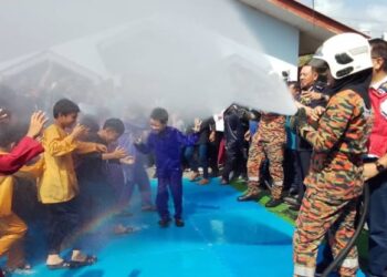 ANGGOTA boma melakukan semburan sebagai gimik memandikan peserta khatan di Sekolah Kebangsaan (SK) Paloh, Pintu Geng, Kota Bharu, Kelantan, hari ini. - UTUSAN/ROHANA MOHD. NAWI