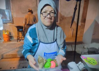 NUR Azreen Ku Abdullah menunjukkan kuih chang (kiri) dan kuih angku yang dijualnya dan mendapat sambutan di Karnival Tahun Baharu Cina Negeri Sembilan di N9 Sungei Ujong Walk, Seremban.-UTUSAN/BADRUL HAFIZAN MAT ISA