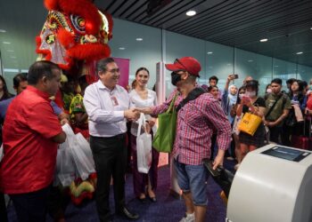 ANTHONY Loke menyerahkan cenderahati kepada penumpang Batik Air Kuala Lumpur - Sibu di KLIA Terminal 1, Sepang, Selangor. - UTUSAN/FAISOL MUSTAFA