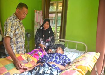 WAN Murni Wan Ngah (tengah) bersama Rosol Wahid (kanan) melihat keadaan Muhammad Amirul Nazmi Sam di rumahnya di Kampung Jaba, Bukit Apit, Hulu Terengganu.