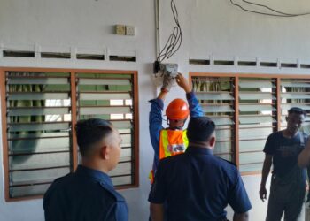 PEKERJA TNB memotong bekalan elektrik di Surau Al-Karamah, Kampung Seri Keramat di Pasir Puteh,  Ipoh semalam. - UTUSAN