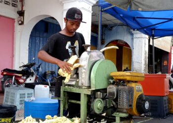 PITMAN Shah Putra menjual air tebu di tepi jalan Chenderiang 
di Tapah. – UTUSAN/MEGAT LUTFI MEGAT RAHIM