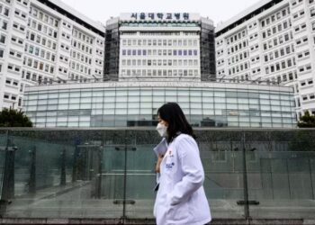 SEORANG pekerja perubatan berjalan melepasi Hospital Universiti Kebangsaan Seoul. - AFP