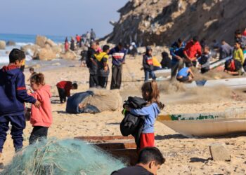 PENDUDUK Palestin berkumpul di kawasan pantai Deir el-Balah sambil menanti bantuan makanan yang disalur dari udara.-AFP