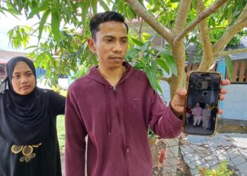 MUHAMMAD Fazli Adnan menunjukkan gambar kenangan arwah ibunya, Manirah Rafiee bersama keluarga.