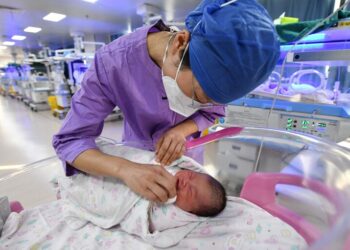 SEORANG jururawat menjaga bayi baru lahir di sebuah hospital di Fuyang, China.-AFP