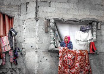 SEORANG wanita Palestin berdiri di tingkap bangunan yang rosak akibat pengeboman Israel di Rafah, selatan Gaza pada 22 Mac lalu. -AFP