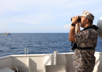 AMILUDIN Yenggah melakukan pemantauan di perairan negara dari Kapal Maritim Jujur di Kelantan kelmarin.-UTUSAN/KAMARUL BISMI KAMARUZAMAN.