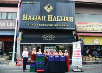 MOHD. Shaiful Hasri Shukri (kiri) bersama kakitangan mengedarkan bubur lambuk secara percuma yang menjadi tradisi sepanjang Ramadan sejak lebih 10 tahun lalu di depan Kedai Emas Hajjah Halijah di Kangar, Perlis. – UTUSAN/IZLIZAN OTHMAN