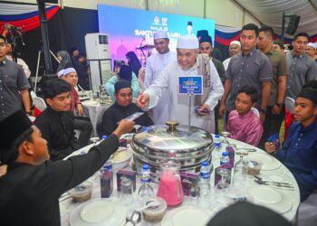 AHMAD Zahid Hamidi (tengah) menyampaikan sumbangan duit raya kepada anak-anak yatim pada Majlis Santunan Kasih Ramadan Kementerian Kemajuan Desa dan Wilayah di Masjid Sultan Mahmud, Bandar Al Muktafi Billah Shah, Dungun, hari ini. - UTUSAN/PUQTRA HAIRRY ROSLI