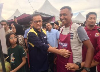 Azman Ismail (kiri) menyampaikan sumbangan apron kepada salah seorang peniaga pada Majlis Pelancaran Bazar Ramadan Rahmah (BRR) Madani di Mydin Mall Tunjong, Kelantan. UTUSAN/ROSMIZAN RESDI.