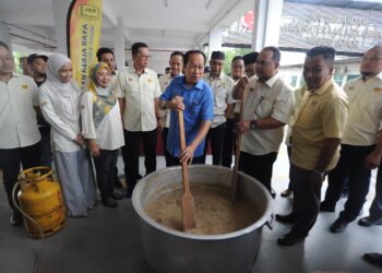 AHMAD Maslan mengacau bubur lambuk selepas mempengerusikan mesyuarat di Ibu pejabat JKR Johor, di  Iskandar Puteri, Johor Bahru.