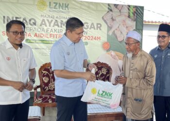 NORIZAN Khazali mengagihkan ayam segar kepada penerima pada Majlis Perasmian Agihan Zakat Ayam Segar kepada Asnaf sempena Aidilfitri 2024 di Masjid Sultanah Haminah, Pendang.