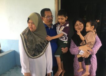 ASMARIANA Othman (kanan) dan suami tabah menguruskan ketiga-tiga anak mereka di Kampung Bechah Mulong, Peringat, Kelantan. 
– UTUSAN/ROSMIZAN RESDI