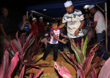 ATTAR Azim  Syukran Jamil menyiram air di pusara keluarganya di Tanah Perkuburan Islam Felda Trolak Utara, Sungkai hari ini. - UTUSAN