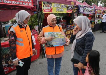 ROSNAH Sardi (tengah) menyampaikan maklumat kepada masyarakat mengenai Kempen Bijak Membantu Elak Tertipu ketika menyertai Op Ramadan 'Helping The Vagrant Community' di Nilai, Seremban, semalam.-UTUSAN/NUR SHARIEZA ISMAIL.