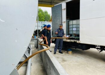 ANGGOTA penguat kuasa KPDN Perak memeriksa tangki berisi cecair disyaki minyak diesel bersubsidi yang dirampas dalam serbuan di sebuah premis di Pusing semalam. - UTUSAN