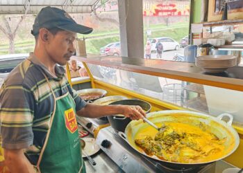 PEKERJA restoran, Abdul Hamid Mahat menyediakan menu istimewa gulai patin tempoyak di restoran Gulai Kampung di Bandar Baru Kuala Lipis semalam. – UTUSAN/NORFARHIZA MOHD ATAR