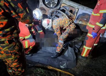 ANGGOTA bomba mengeluarkan mangsa yang rentung dalam kebakaran kereta di Jalan Changkat Jong-Bidor dekat Kampung Ayer Hitam, Teluk Intan hari ini. - UTUSAN/IHSAN JBPM PERAK