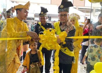 AZMAN Ismail (kanan) memotong riben sebagai simbolik pembukaan Cawangan Keempat Raja Perfume dan pelancaran Minyak Wangi Jenama Boyo Temago di Jelawat, Bachok, Kelantan hari ini.UTUSAN/TOREK SULONG.