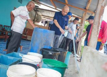 ARMIZAN Mohd. Ali membantu mengisi air ke dalam bekas di Kampung Kuala, Papar, Sabah bagi kegunaan penduduk terjejas  sejak dua bulan lalu.