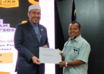 DR. Izani Husin (kiri) ketika menyampaikan surat lantikan kepada salah seorang kontraktor yang terpilih pada Majlis Cabutan Kerja Undi Mega JKR Cawangan Kejuruteraan Elektrik Negeri Kelantan Bil.1/2024 di Kompleks Kota Darulnaim, Kota Bharu, Kelantan hari ini. UTUSAN/MUSTAQIM MOHAMED.