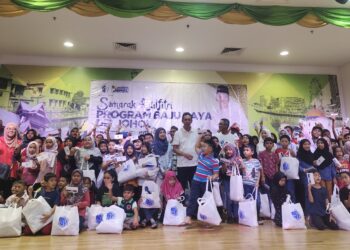 SAIFUL Yazan Sulaiman (tengah) bergambar bersama murid dan pelajar yang menerima bantuan sempena program Semarak Aidilfitri Program Baju Raya De' Johol, di Tampin hari ini.-UTUSAN/NOR AINNA HAMZAH