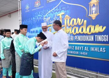 ZAMBRY Abd. Kadir (kanan) menyampaikan sumbangan kepada pelajar pada Majlis Berbuka Puasa UMNO Bahagian Lumut di Maahad Tahfiz Bayt Al-Ikhlas, Kampung Padang Tembak, Lumut hari ini. - UTUSAN