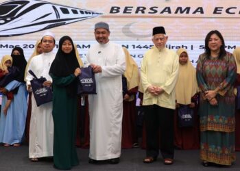 DR. IZANI Husin (tiga, kanan) menyerahkan sumbangan kepada anak-anak yatim diraikan pada Majlis Berbuka Puasa Bersama ECRL di Kota Bharu, Kelantan semalam. - UTUSAN/KAMARUL BISMI KAMARUZAMAN