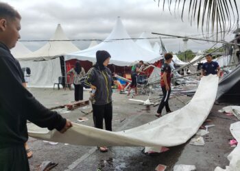 PENIAGA mengemas peralatan niaga mereka setelah khemah rosak dilanda ribut di Bazar Syawal Pekan Rabu, Langkawi.